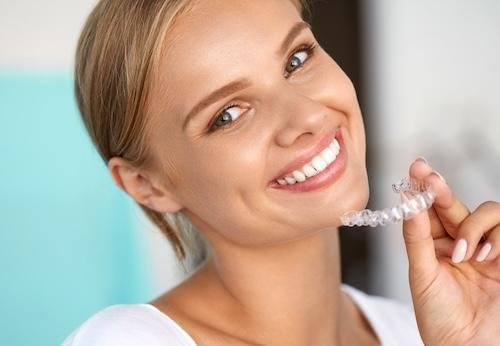 invisalign norwood | woman holding aligners