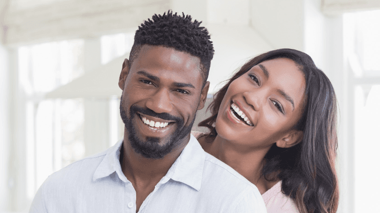 younger couple hugging inside | dentist dedham ma
