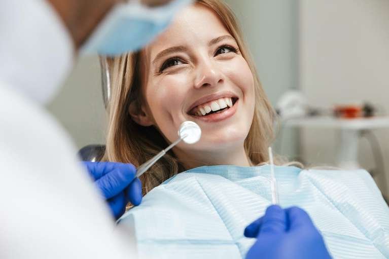 woman smiling in dentist exam chair | dentist dedham ma